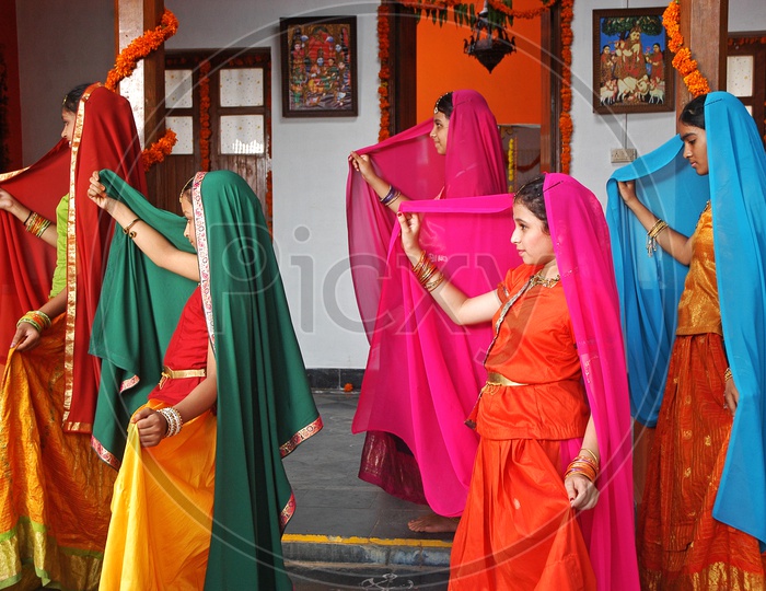 A group of girls dancing in Indian traditional wear in the house