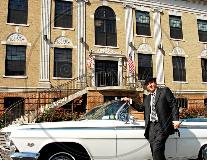 A Man posing by the vintage car