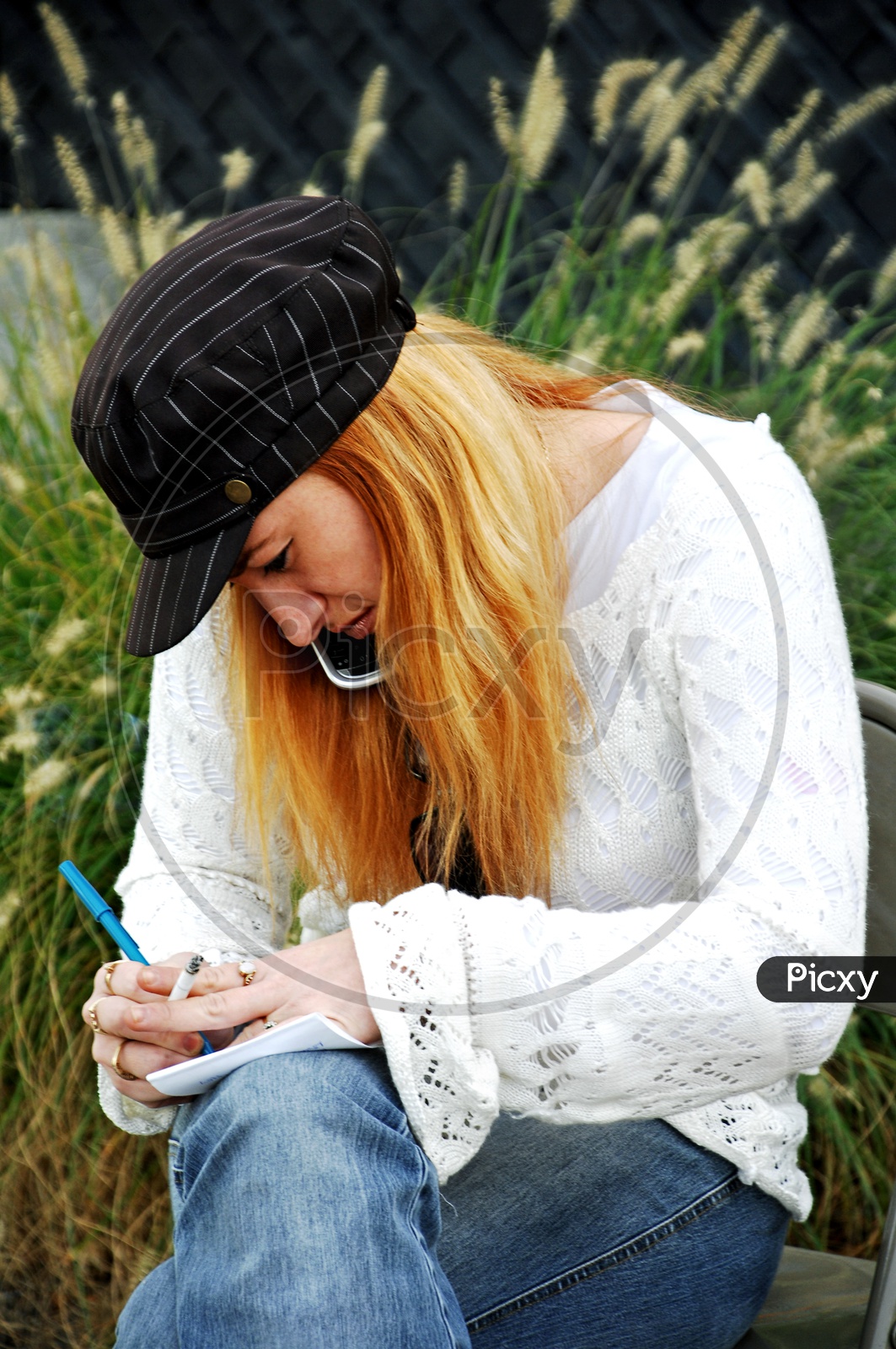 A blonde woman writing on a scribble book