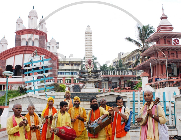 Devotees with musical instruments in front of a temple