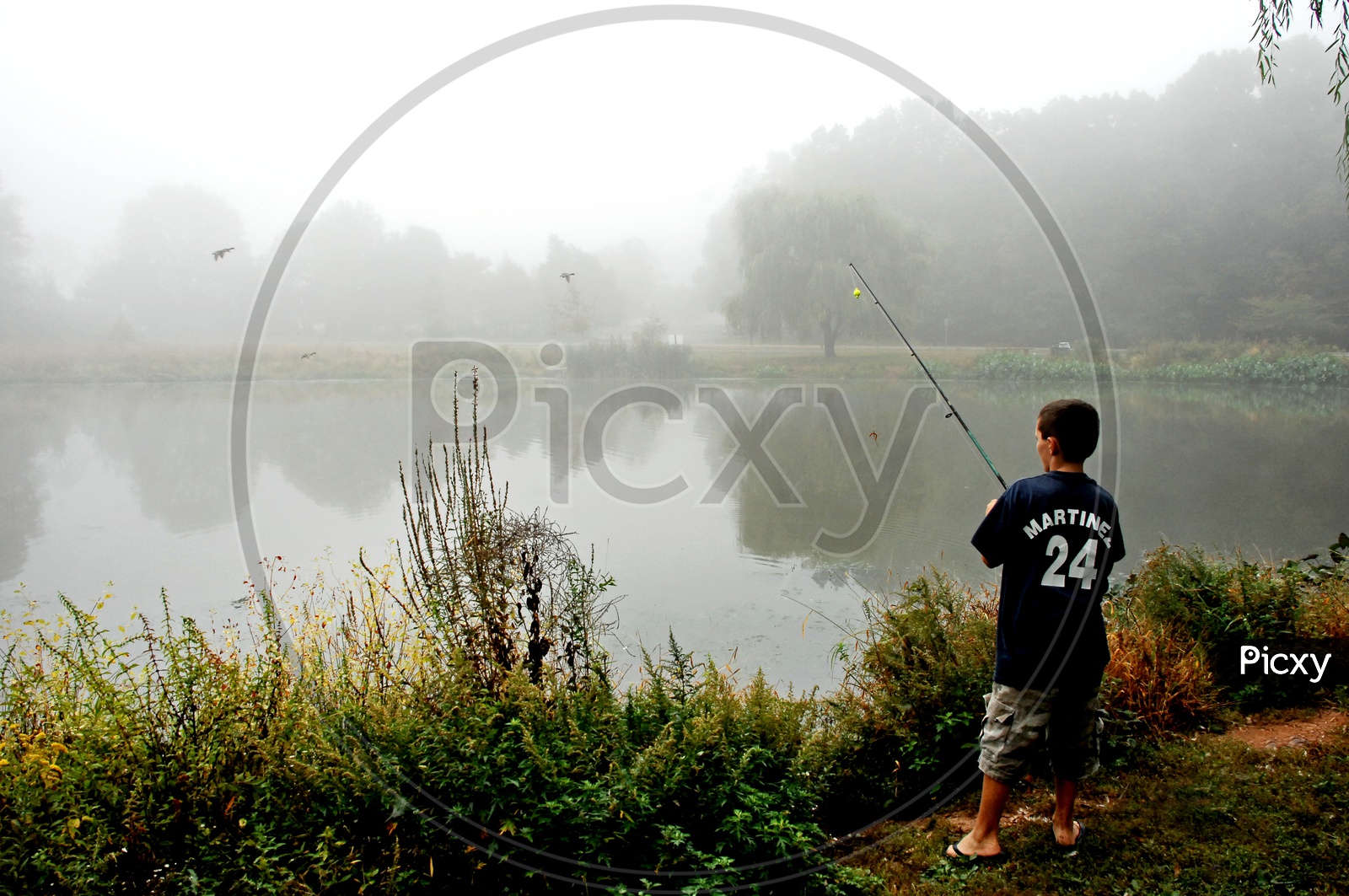 A boy fishing by the lake