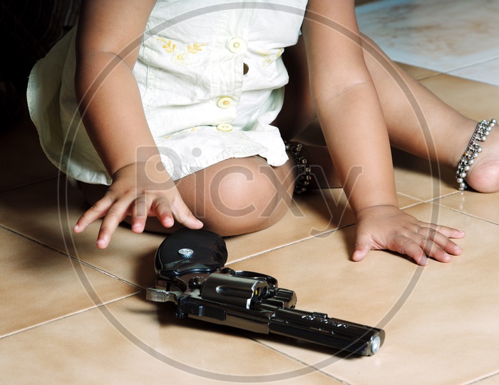A little kid holding the revolver