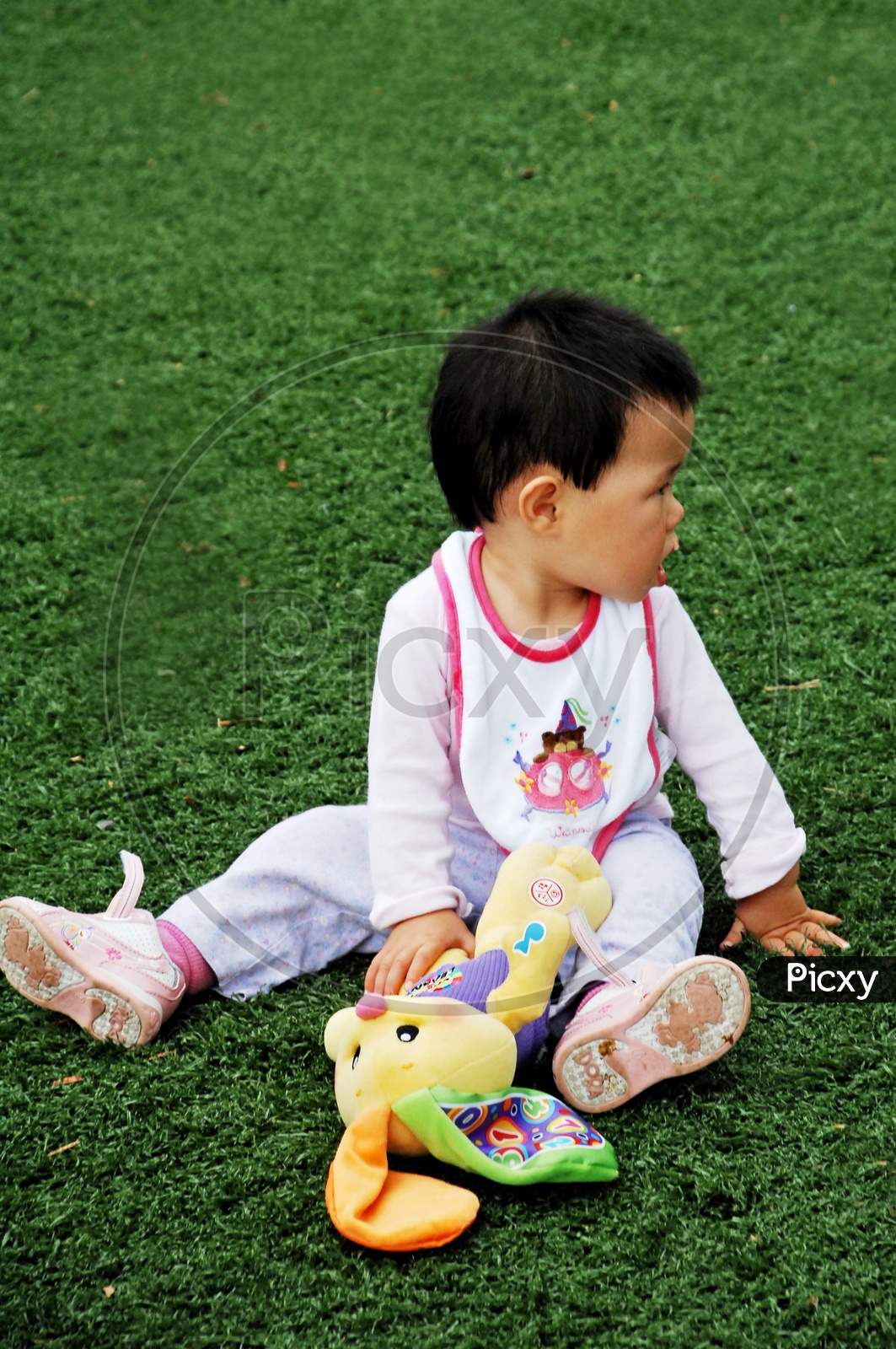 Toddler on the lawn with a toy