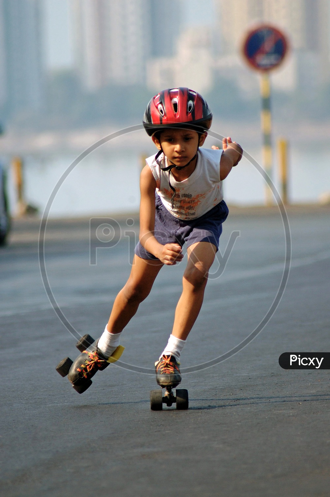 A boy skating with a helmet on the road