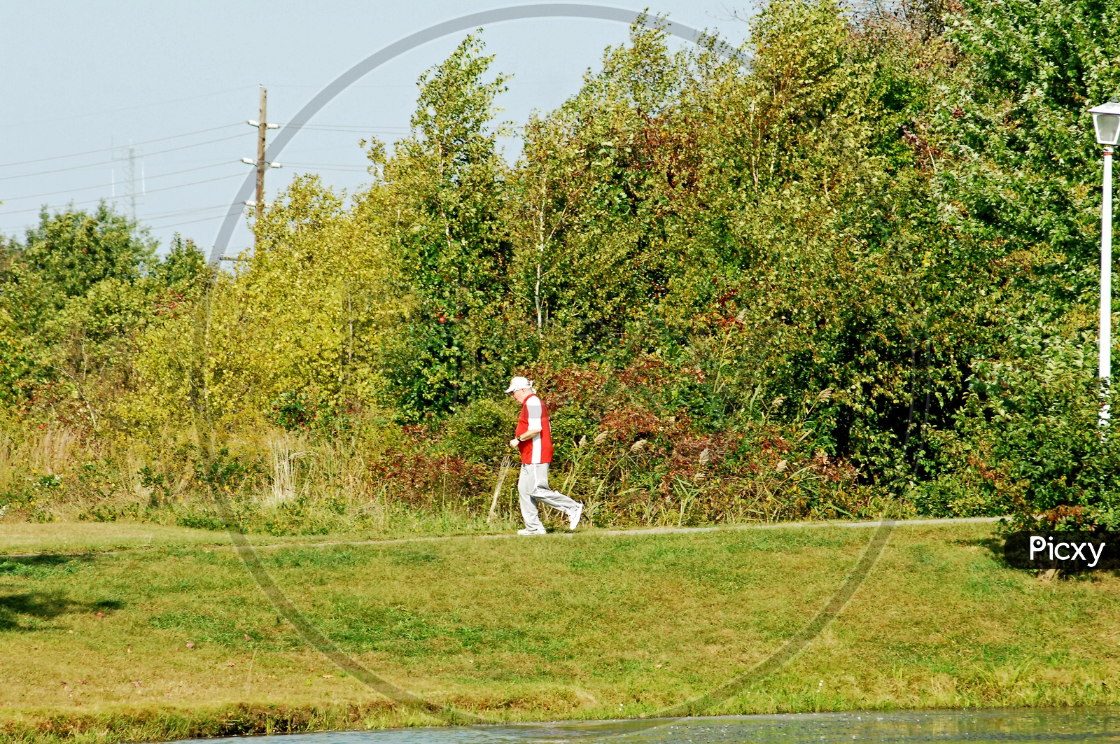 An old man jogging in a park