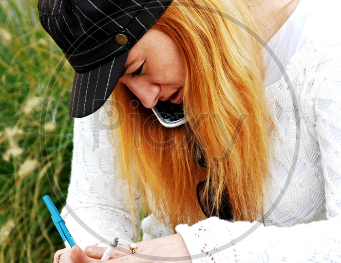 A blonde woman writing on a scribble book