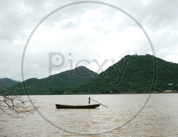 Rural boy sailing the boat on the River Godavari