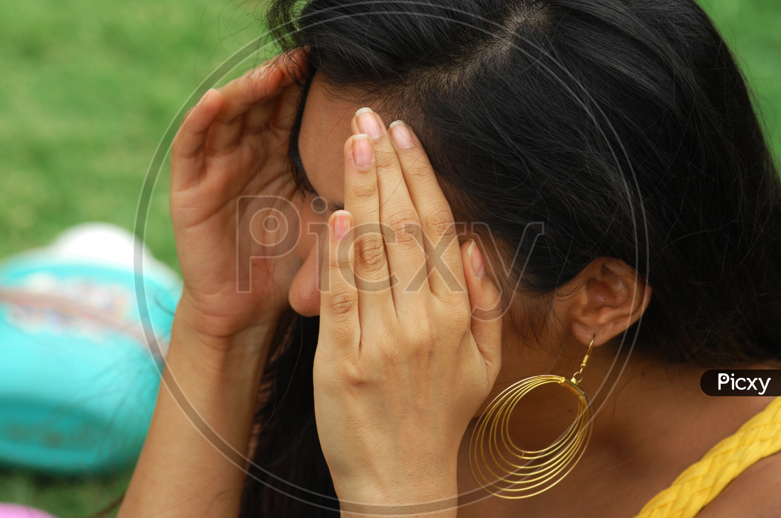 An Indian woman covering her face with hands