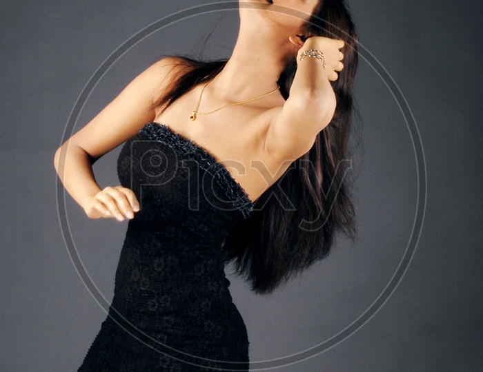 A female model posing with Shoulderless black frock