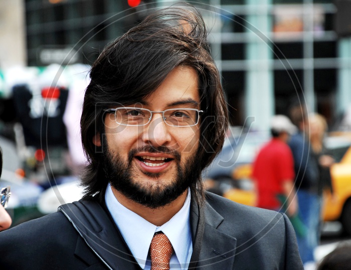 Indian man with long hair wearing glasses