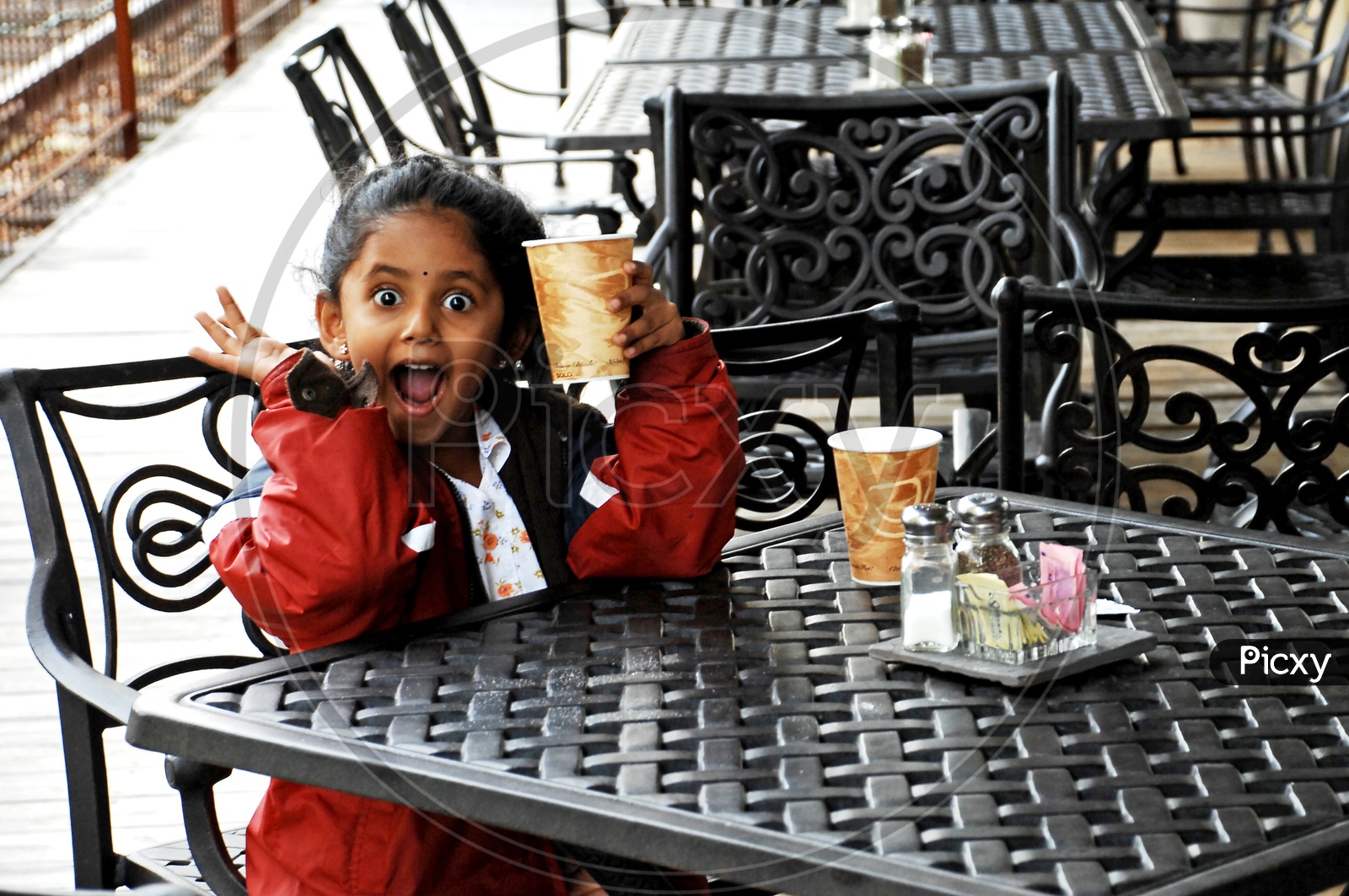 Indian little girl sitting in a cafe