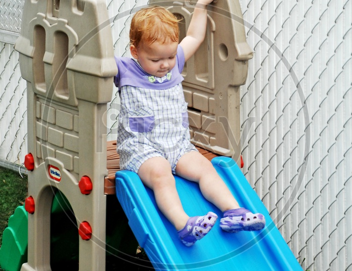 Toddler sliding down the slide