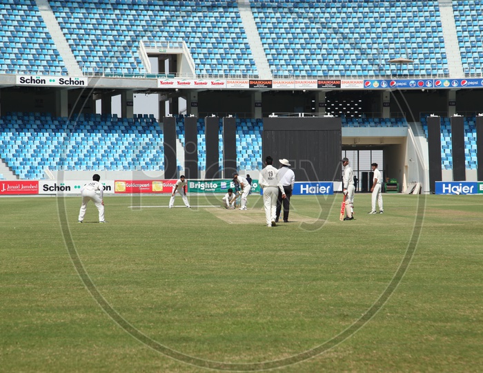Cricketers Playing Cricket In a  Stadium