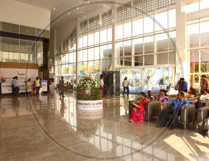 Hospital Reception Floor With Patients Waiting at Chairs
