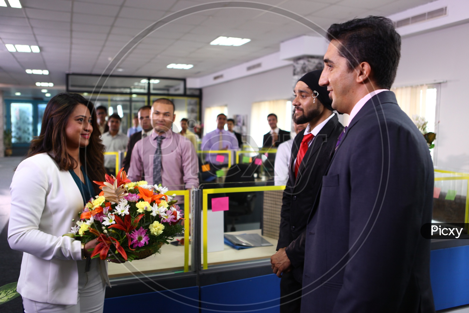 Office Staff Welcoming Young Lady Boss Into Office With a Flower bouquet