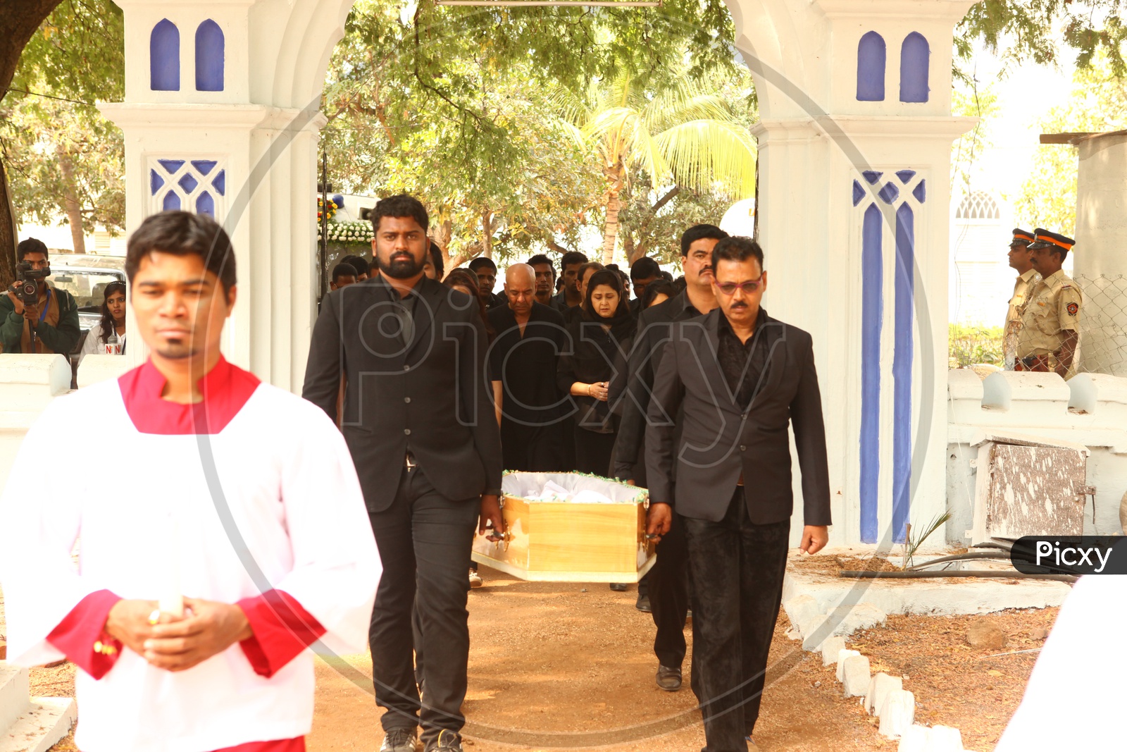 Men Dressed In Black Suits Carrying Funeral Box Or Coffin Box To Crematorium