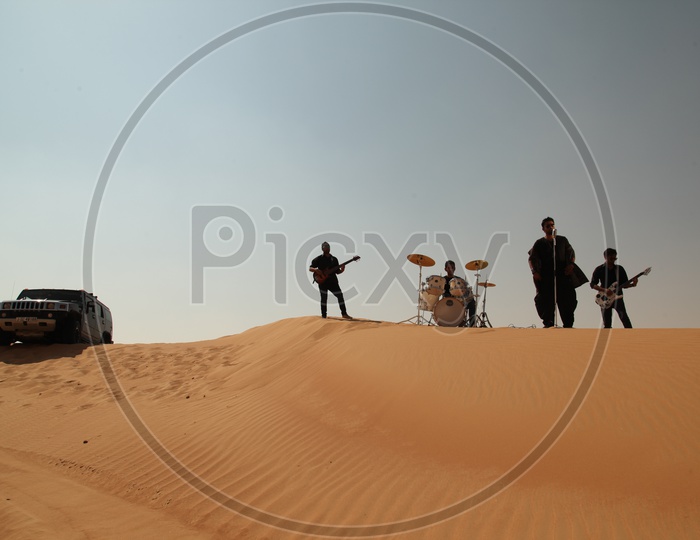A Music Band Performing In Desert Sand Dunes For a Music album