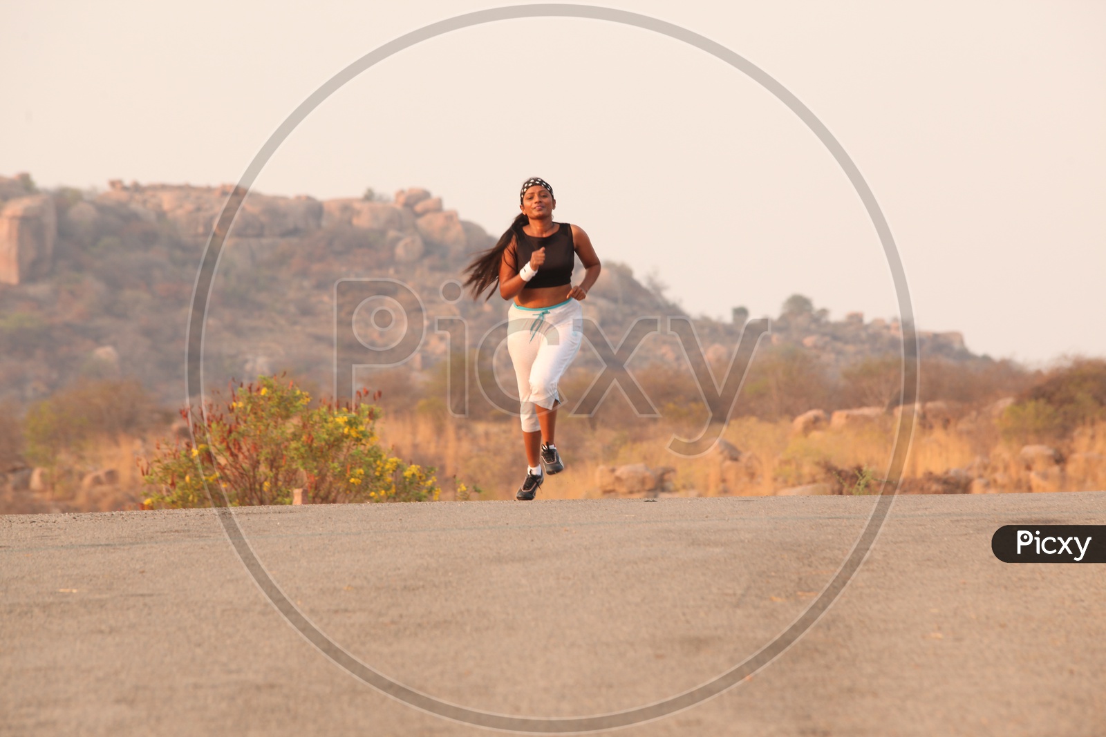 A Young Lady Athlete Running on Road