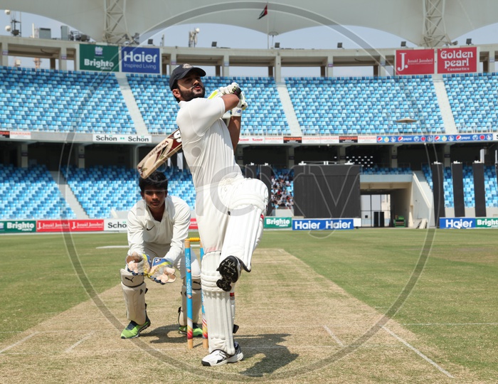 Image of Fielder rubbing the cricket ball over his pantPT327449Picxy