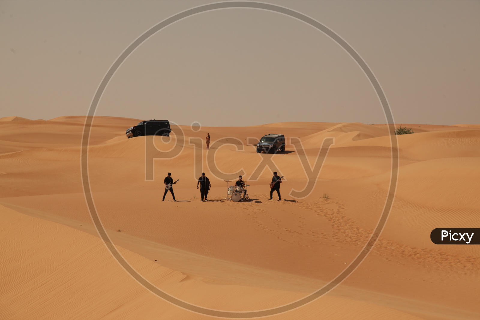 A Music Band Performing On Sand Dunes of a Desert For Music Album