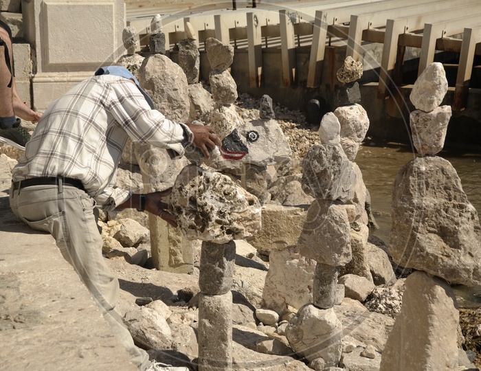 a Man Arranging Stones One On Another