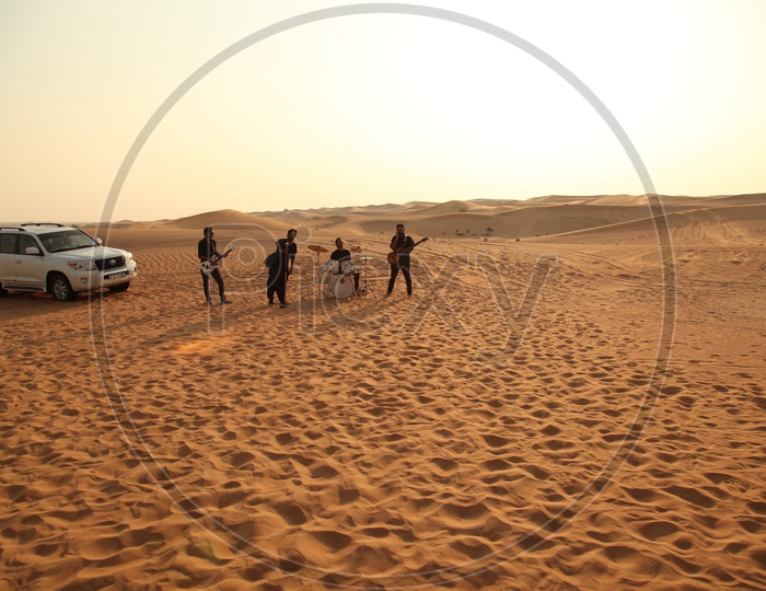 A Music Band Performing On Sand Dunes of a Desert For Music Album