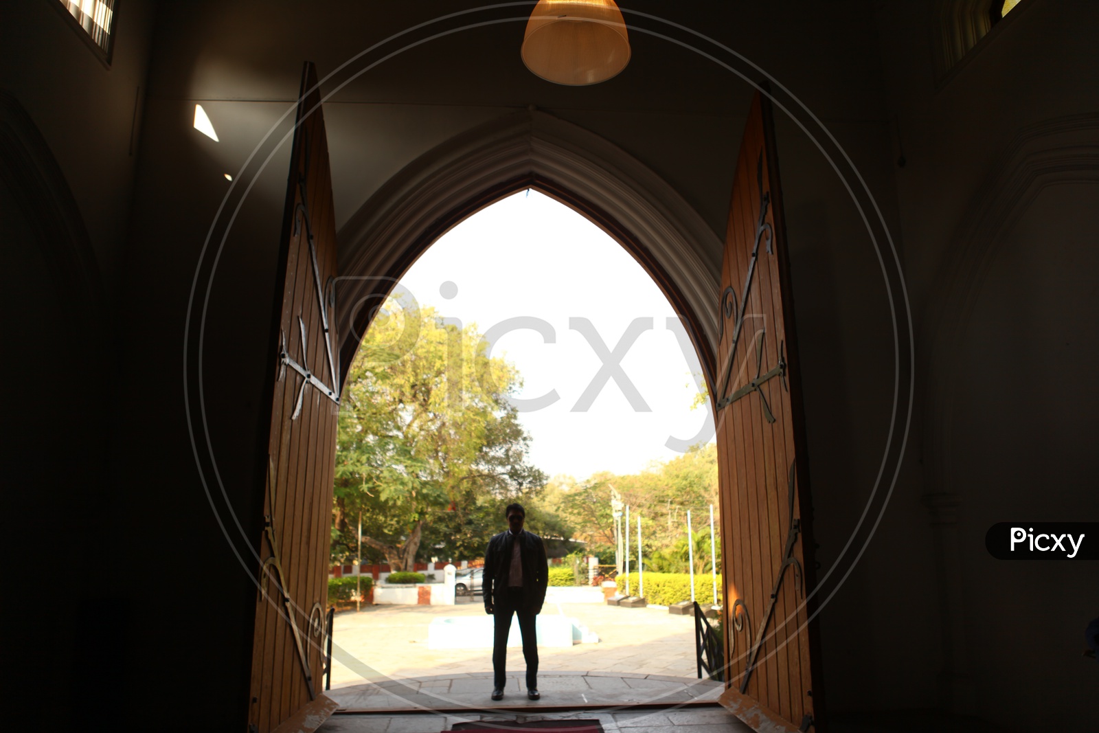 Silhouette Of  a Man Standing at a Church Door Entrance