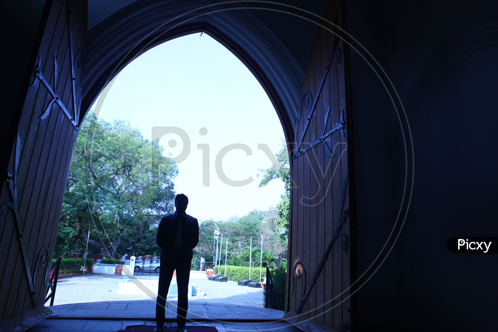Silhouette of a Man Standing at a Church Entrance Door