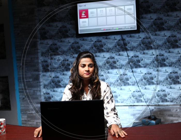 A Young Office Going Woman In Office Cabin With a Laptop On table
