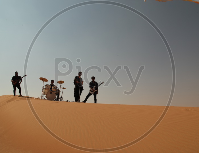 A Music Band Performing In Sand dunes of A Desert