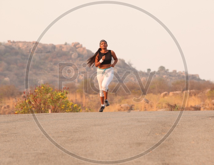 A Young Lady Athlete Running on Road