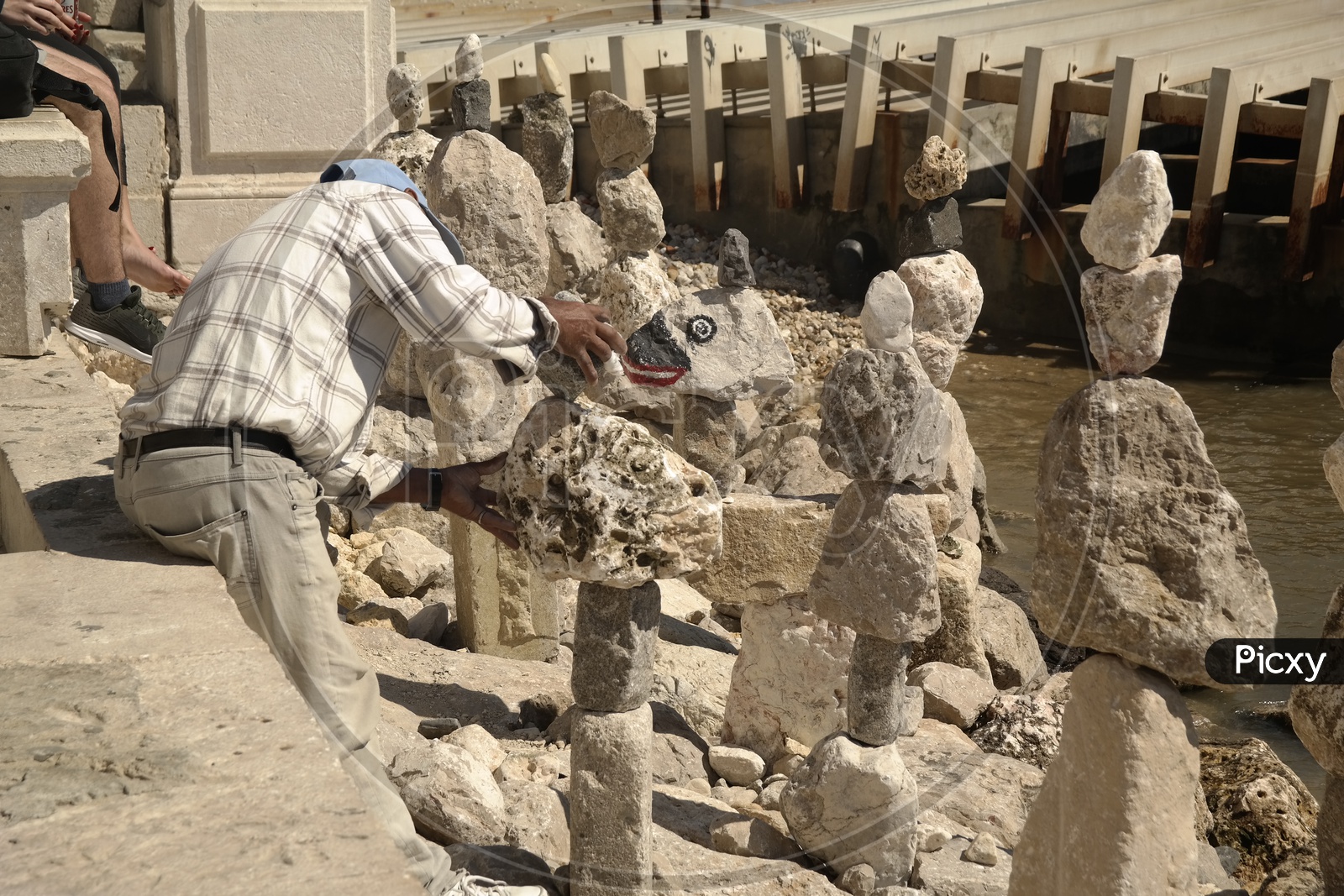 a Man Arranging Stones One On Another