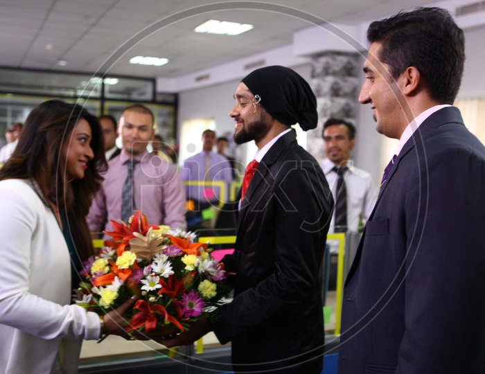 Office Staff Welcoming Young lady Entrepreneur with a Flower bouquet