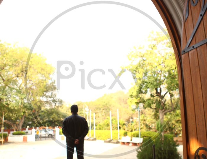 Silhouette Of  a Man Standing at a Church Door Entrance