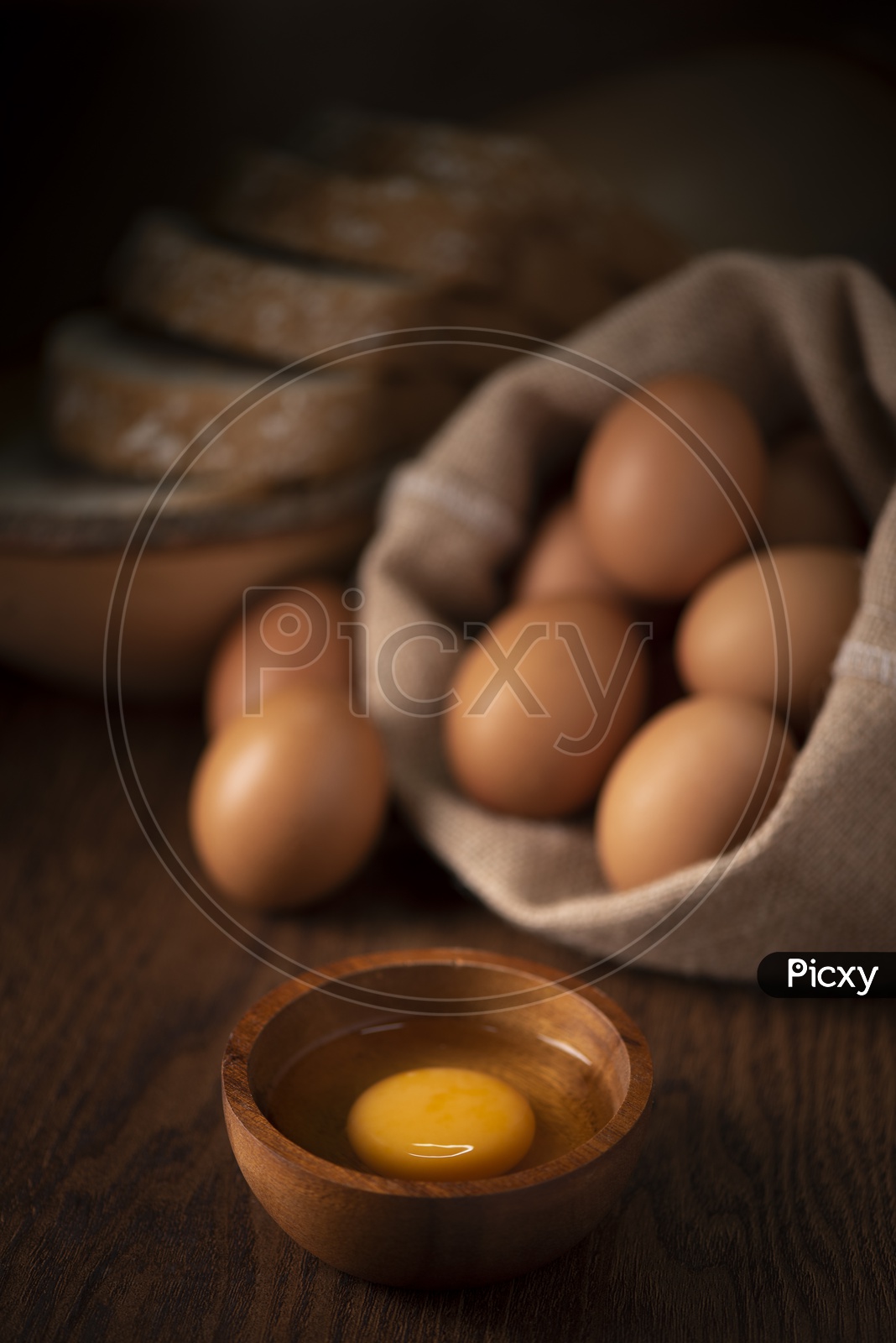 Fresh Brown Eggs In a Sack , Broken Egg With Yolk In a Bowl