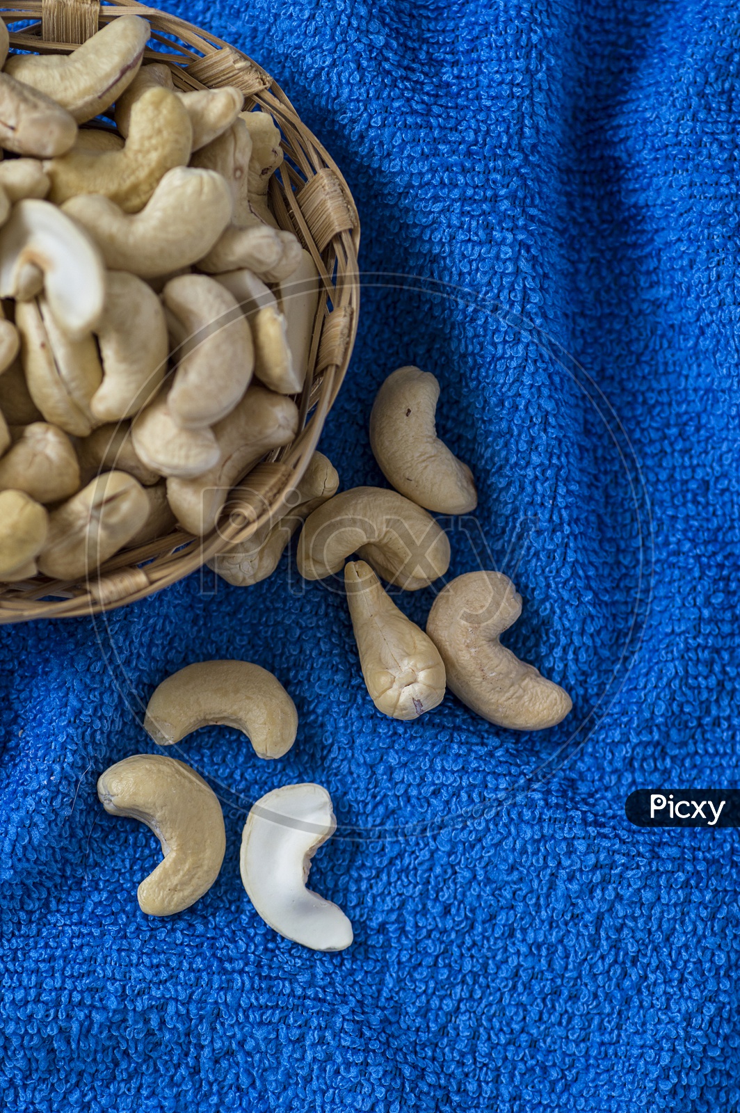 Cashew nuts in a basket on blue cloth