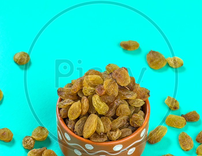 Dry Grapes Or Raisins  Heap in a Clay Bowl On an Isolated Green  Background