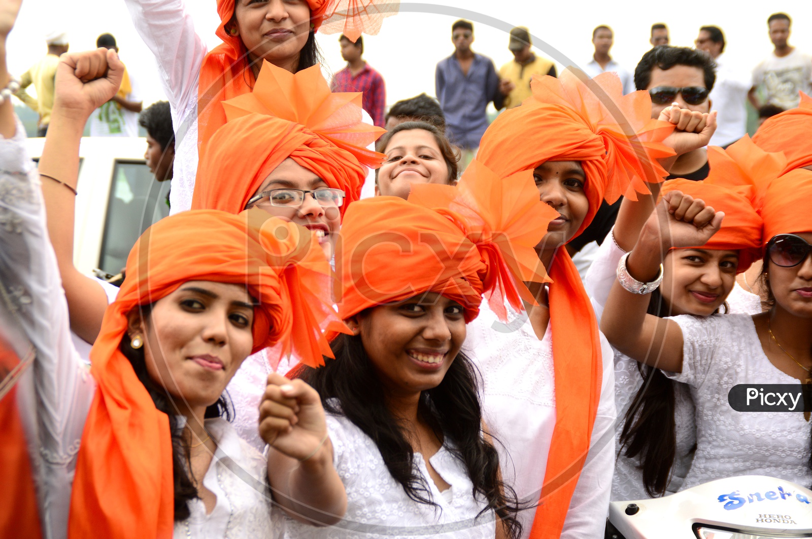 Image of Indian Young Girls Wearing Saffron Turbans And White Clothes
