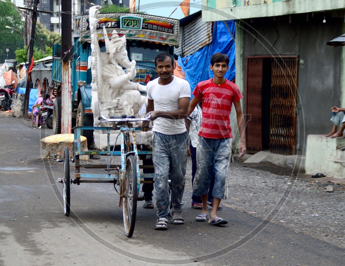 An Artists Transporting Lord Ganesh Idol In Rickshaw Between Workshops