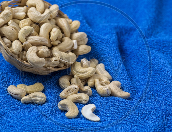 Cashew nuts in basket on blue cloth