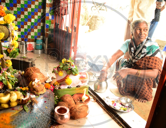 Indian old woman offering prayers in a temple