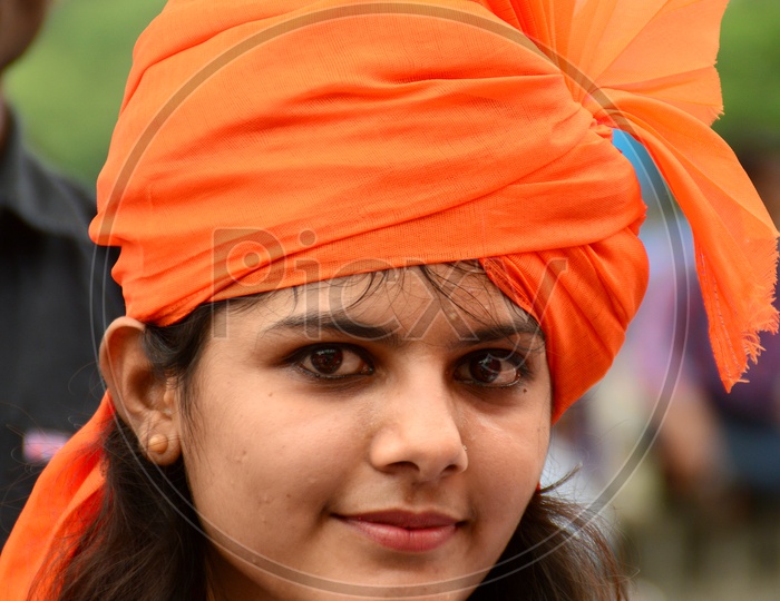 Image of Indian Young Girls Wearing Saffron Turbans And White Clothes