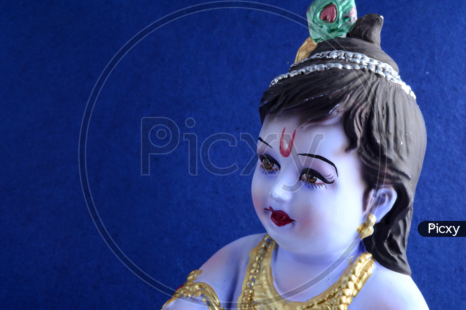Image of Little Krishna Idol on dark blue background-RJ713902-Picxy