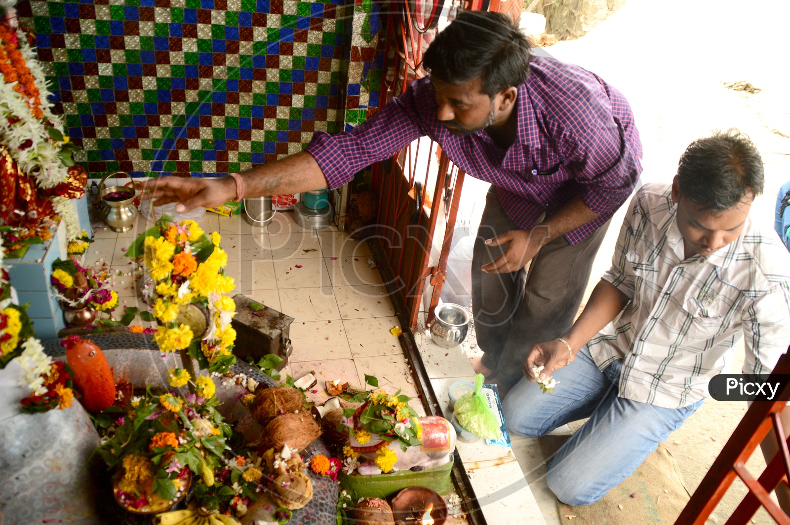 Indian men offering prayers in a temple