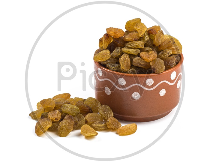 Dry Grapes Or Raisins  Heap in a Clay Bowl On an Isolated White Background