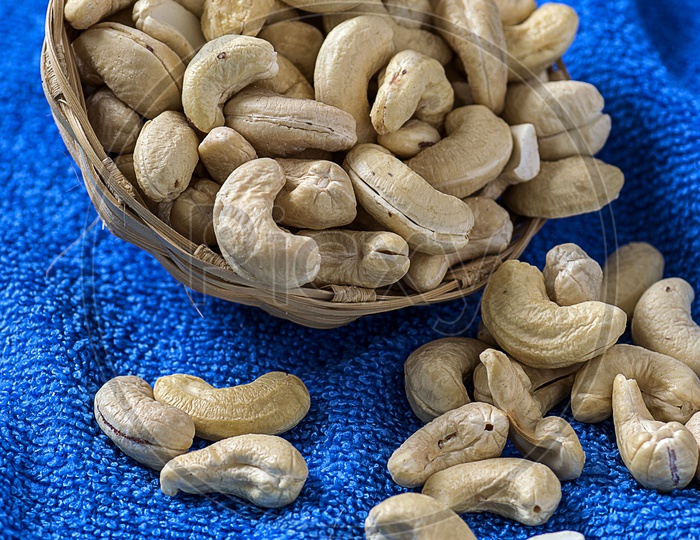 Cashew nuts in basket on blue cloth