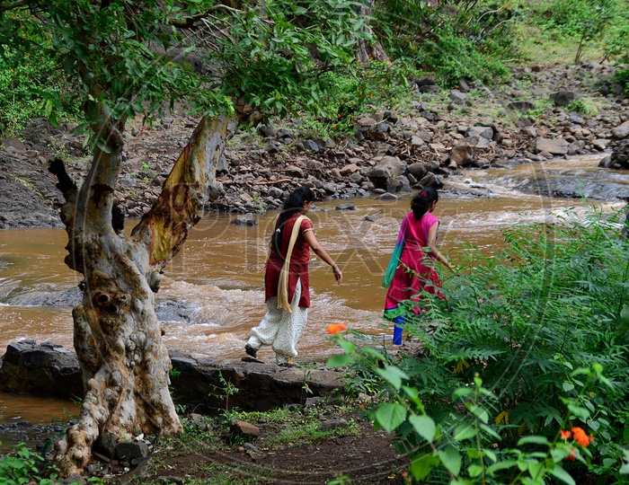 Women crossing the flow of water