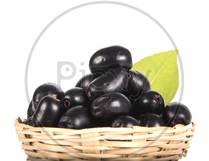 Jambolan plum or Java plum (Syzygium cumini) or Berry  Fruit In a Wooden Weaved Basket On an Isolated White Background