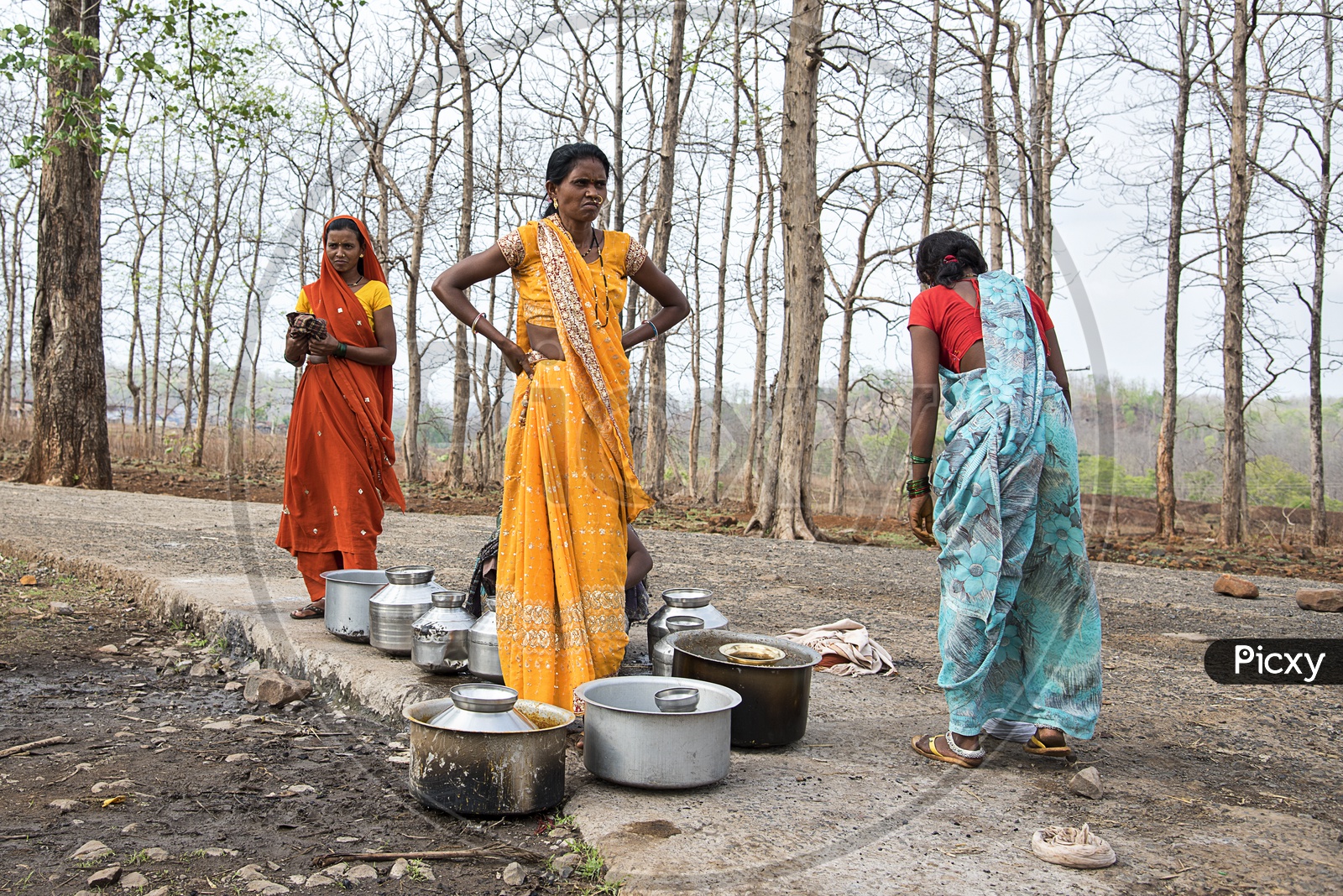 Unidentified rural Indian women carry water on their heads in traditional pots from hand pump, everyday Women walk few kilometers to get it due to drought.