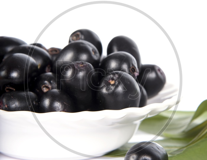 Jambolan plum or Java plum (Syzygium cumini) or Berry  Fruit In a Bowl  On an Isolated White Background